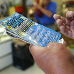 A man scratched a lottery ticket at Tan-Thang Market on Broadway in Chelsea. 