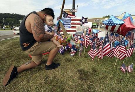 Bryan Thaboua knelt with his 8-month-old son in front of the Lee Highway memorial for last Thursday's Chattanooga, Tenn., shooting victims.
