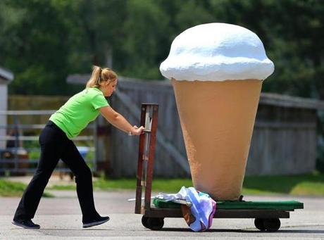 Kylee McLaughlin pushed a giant ice cream cone display to the front of the parking lot of the Sugar Hill Dairy at Hanson Farm in Bridgewater for the noon opening on Tuesday.
