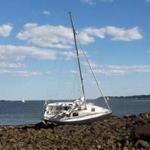 A sailboat carrying the body of a man who appeared to be in his 70s ran aground at Lynch Park in Beverly on Friday afternoon. 