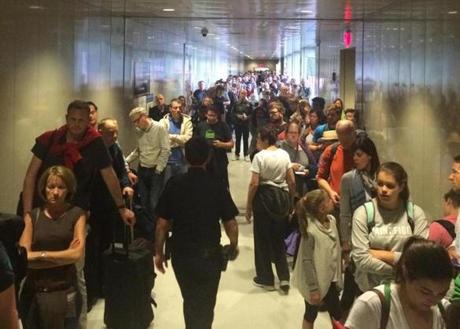 Long lines for international travelers waiting to clear customs at Logan Airport on a Sunday in June.
