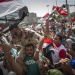 An Egyptian carried a member of the armed forces on his shoulders in downtown Cairo during celebrations of the opening of a new side channel to the Suez Canal. 