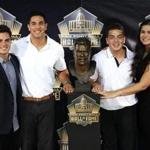 The children of Junior Seau ? Tyler Seau and Jake Seau and Hunter Seau and Sydney Seau ? pose with the bust of their father during the 2015 Pro Football Hall of Fame enshrinement.