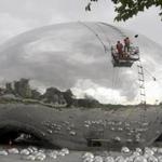 Workers polished a new sculpture in the shape of a giant oil bubble at a tourism resort built near the first drilling well of the Karamay oil field in China.