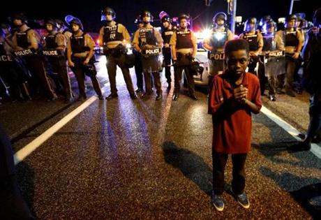 Amarion Allen, 11-years-old stands in front of a police line shortly before shots were fired in a police-officer involved shooting in Ferguson, Missouri, on Sunday.
