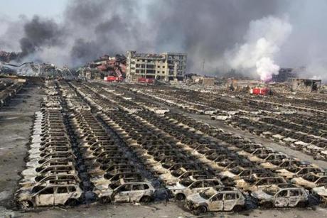 Smoke billowed from the site of an explosion that reduced a parking lot filled with new cars to charred remains at a warehouse in northeastern China's Tianjin municipality.
