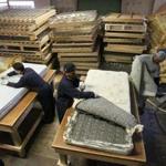 A worker in Lawrence began the process of taking apart a mattress for recycling.