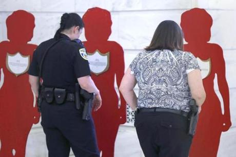 Members of the Sherwood, Ark., police force read accounts of domestic violence placed on painted cutouts in Little Rock last month. 
