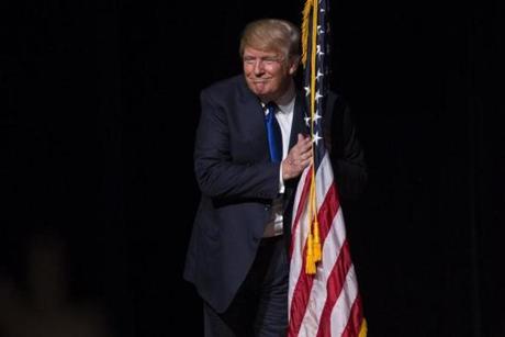 Donald Trump hugged an American flag as he took the stage for a town hall meeting in Derry, N.H.
