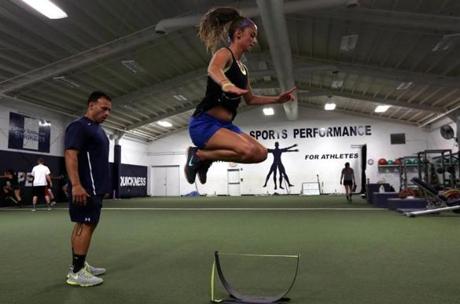 Medway High soccer player Shannon Simmons is guided through a workout by Craig Belanger at his facility in Easton.
