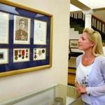 Hingham senior clerk Tania Layden looks at the display honoring Medal of Honor recipient Herbert Foss in the Hingham town hall lobby.
