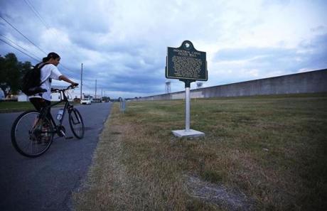 A cyclist stood near the re-constructed levee wall along the Industrial Canal in the Lower Ninth Ward in New Orleans on Saturday.
