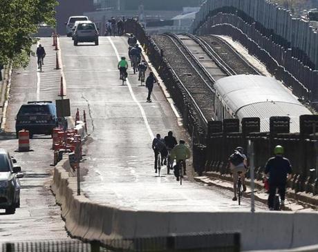 Bicyclists and vehicles crossed the Longfellow Bridge from Cambridge into Boston.
