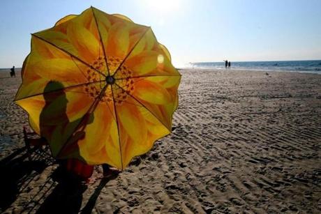 Jose Triana, of Walpole, closed his umbrella after spending the day at Mayflower Beach.
