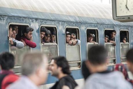 In this Sept. 5, 2015 photo migrants look out of the windows of a train bound for Germany at the railway station of Gyor, 120 kms west of Budapest, Hungary, Saturday, Sept. 5, 2015, after the the Austrian and the German government allowed the migrants staying in Hungary to enter their countries. (Csaba Krizsan/MTI via AP)
