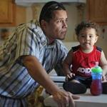 Edwin Melendez, with his son Caleb at their apartment in Worcester, can?t afford to get his driver?s license restored. 
