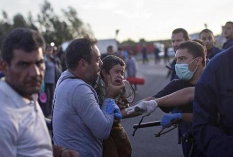 A man held his child as he tried to talk to Hungarian police officers in Roszke in southern Hungary.
