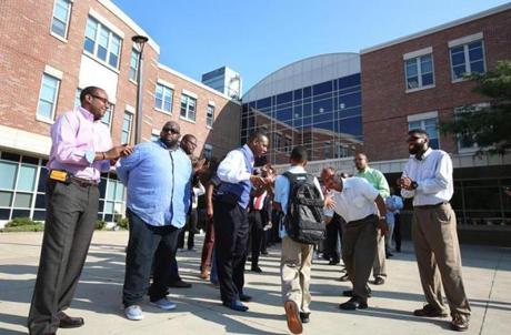 Students at the Lilla G. Frederick Pilot Middle School walked a friendly gauntlet of community men, during a 