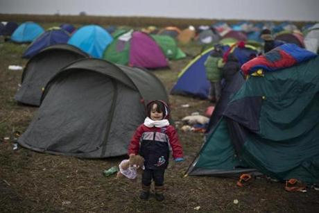 A Syrian refugee child held a teddy bear while standing near her family's tent at a makeshift camp for asylum seekers in southern Hungary. 
