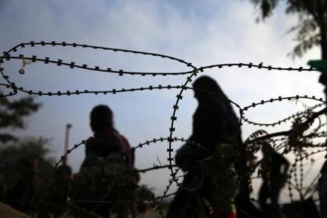 09/16/2015 Idomeni, Greece â??Refugees and migrants pass razor wire as they enter Macedonia at the boarder crossing outside of Idomeni, Greece, September 16, 2015. From there the migrants will travel by train or bus to the Serbian boarder. (Craig F. Walker / Globe Staff) 
