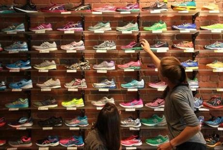 Customer service is a big selling point for stores like Marathon Sports on Boylston Street, where Lauren Roth helped fit customers trying on running shoes. 
