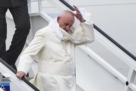 Pope Francis tried to catch his skull cap after he landed on a windy runway in Havana.
