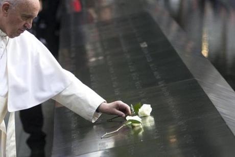 Pope Francis places a white rose at the south pool of the 9/11 Memorial in downtown Manhattan, Friday, Sept. 25, 2015, in New York. (AP Photo/John Minchillo)
