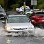 After heavy morning rains, cars made their way through huge puddle on Bridge Street in Salem.