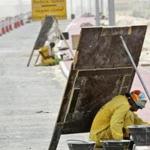 A laborer in Dubai avoided the sun on a scorching June day by working behind a wooden sign.