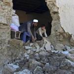 A man and his son cleared rubble from their home in Nangarhar province, Afghanistan, on Tuesday, one day after a massive earthquake shook the region.