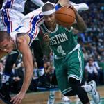 T.J. McConnell of the 76ers lands on the back of Isaiah Thomas as the Celtics guard drives to the hoop. 