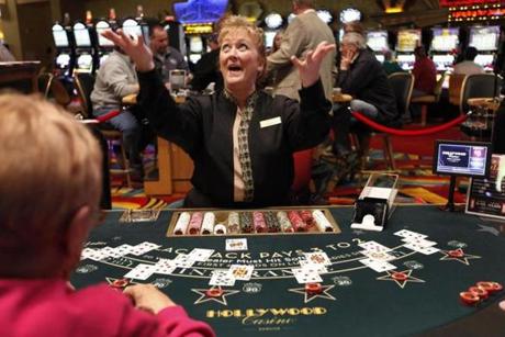 The blackjack dealer announced a winning hand at Hollywood Casino in Bangor, where the early crowds (below) have since gestures after dealing a winning hand at Hollywood Slots, Friday, March 16, 2012
