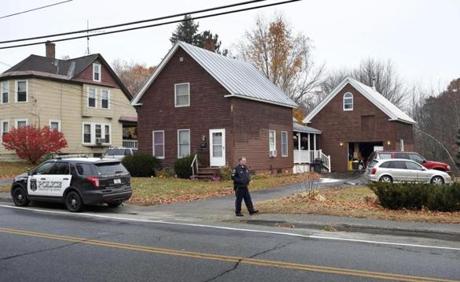 A police officer walked outside a house where two women and a man were shot to death in Oakland, Maine, on Thursday.
