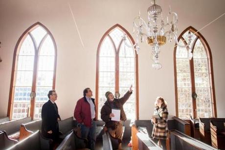 Conservator Brian Powell (second from right) talked about artifacts of the shuttered St. Paul?s Church in Otis Monday with (from left) the Reverend Stephen T. Ayres of Old North Church; Steven Abdow, an Episcopal official; and colleague Lauren Drapala.
