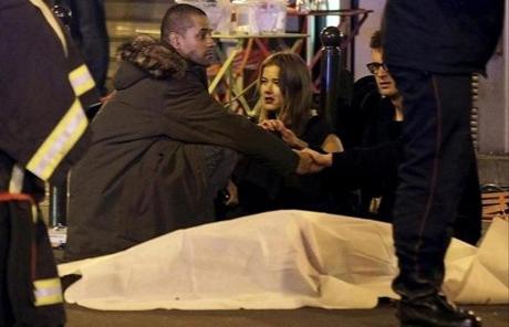 Rescue services personnel worked near the covered bodies outside a restaurant following a shooting incident in Paris. 
