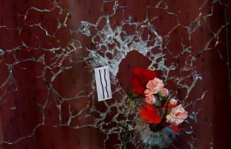 Flowers were left Sunday on a shattered window at a restaurant targeted in Friday?s terrorist attacks.
