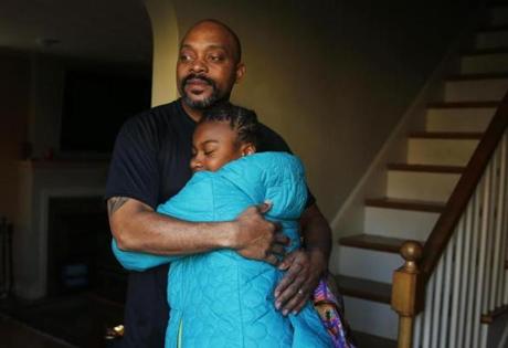 Arthur Brewster hugged his adopted daughter Ty-Janee Brewster, 12, as she returns home from school to her home.  
