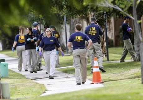 FBI agents search outside a home in connection to the shootings in San Bernardino, Thursday, Dec. 3, 2015, in Redlands, Calif. A heavily armed man and woman opened fire Wednesday on a holiday banquet for his co-workers, killing multiple people and seriously wounding others in a precision assault, authorities said. Hours later, they died in a shootout with police. (AP Photo/)
