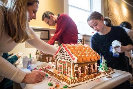 Meredith Whalen and her daughter Paige work on their gingerbread houses.
