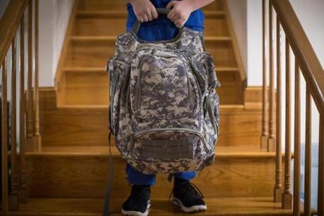 Nicholas Abreau posed for a portrait with the bullet resistant backpack his father Charles bought him in their home in Lowell, MA. 
