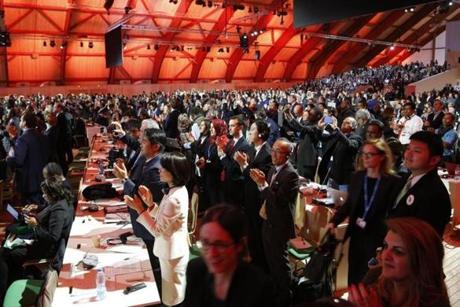 Audience members and delgates cheers after the adoption of a historic global warming pact at the COP21 Climate Conference in Le Bourget, north of Paris, on December 12, 2015. Envoys from 195 nations on December 12 adopted to cheers and tears a historic accord to stop global warming, which threatens humanity with rising seas and worsening droughts, floods and storms. AFP PHOTO / FRANCOIS GUILLOTFRANCOIS GUILLOT/AFP/Getty Images
