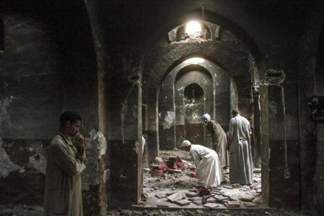 Egyptian Christian villagers seached for salvageable items after a monestary chapel in Dalga was looted and burned in 2013. 
