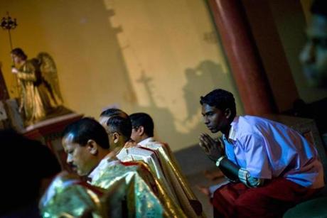 An altar boy at a midnight service at Our Lady of Charity Church in Raikia, India. Christians in India face persecution for their faith.
