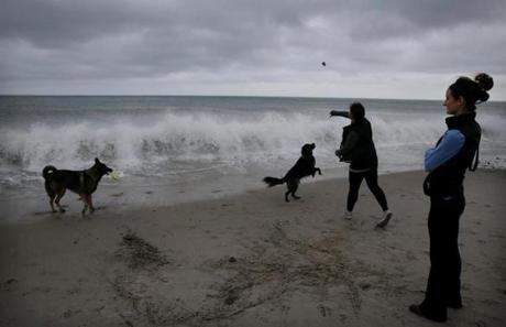 Lindsey Morrison, right, watched as her sister Danielle Morrison-Corvese played with their dogs at Rexhame Beach in Marshfield. 
