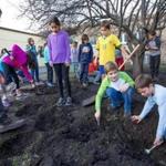 Students at the Zervas Elementary School in Newton attempt to dig up a time capsule that was buried in the 1980s. 