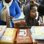Taurean Alexander, 7, looked over books during a gift giveaway at Saint Peter's Teen Center on Christmas Eve.  