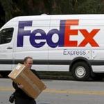 A FedEx delivery worker carrieds a package for a delivery in Wilmette, Illinois in October. 