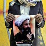 In October 2014, a supporter of the Yemeni Shiite Houthi movement held a banner depicting Saudi Shiite leader Sheikh Nimr al-Nimr, who was executed on Saturday.