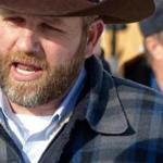 Ammon Bundy chatted with a protester Saturday during a march on behalf of a Harney County ranching family in Burns, Ore.