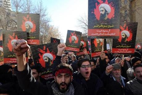 Iranian men hold portraits of prominent Shiite Muslim cleric Nimr al-Nimr during a demonstration against his execution by Saudi authorities, on January 3, 2016, outside the Saudi embassy in Tehran. Iran and Iraq's top Shiite leaders condemned Saudi Arabia's execution of Nimr, warning ahead of protests that the killing was an injustice that could have serious consequences. AFP PHOTO / ATTA KENAREATTA KENARE/AFP/Getty Images
